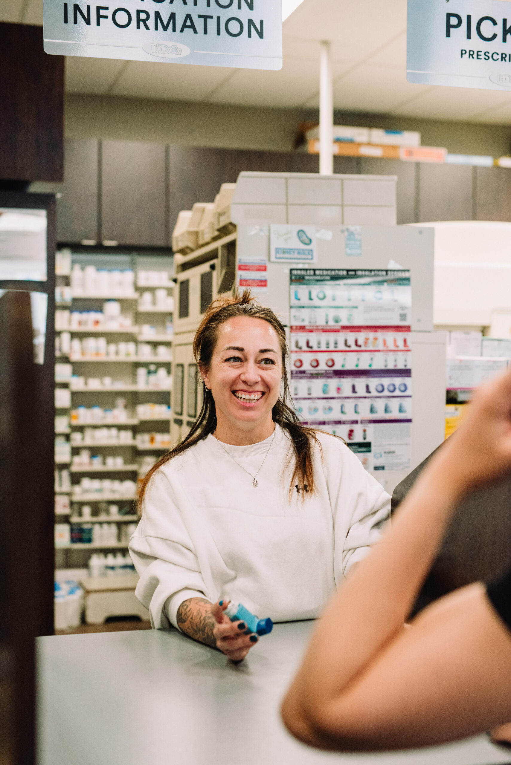 A technician handing a customer their prescription in downtown Kamloops.