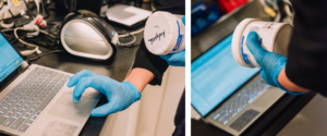 Pharmacy technician preparing prescription compounds with containers and laptop in compounding lab