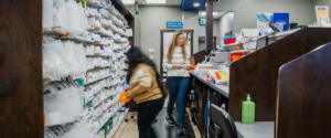 Pharmacy team organizing and preparing prescriptions behind the counter in a busy Kamloops pharmacy